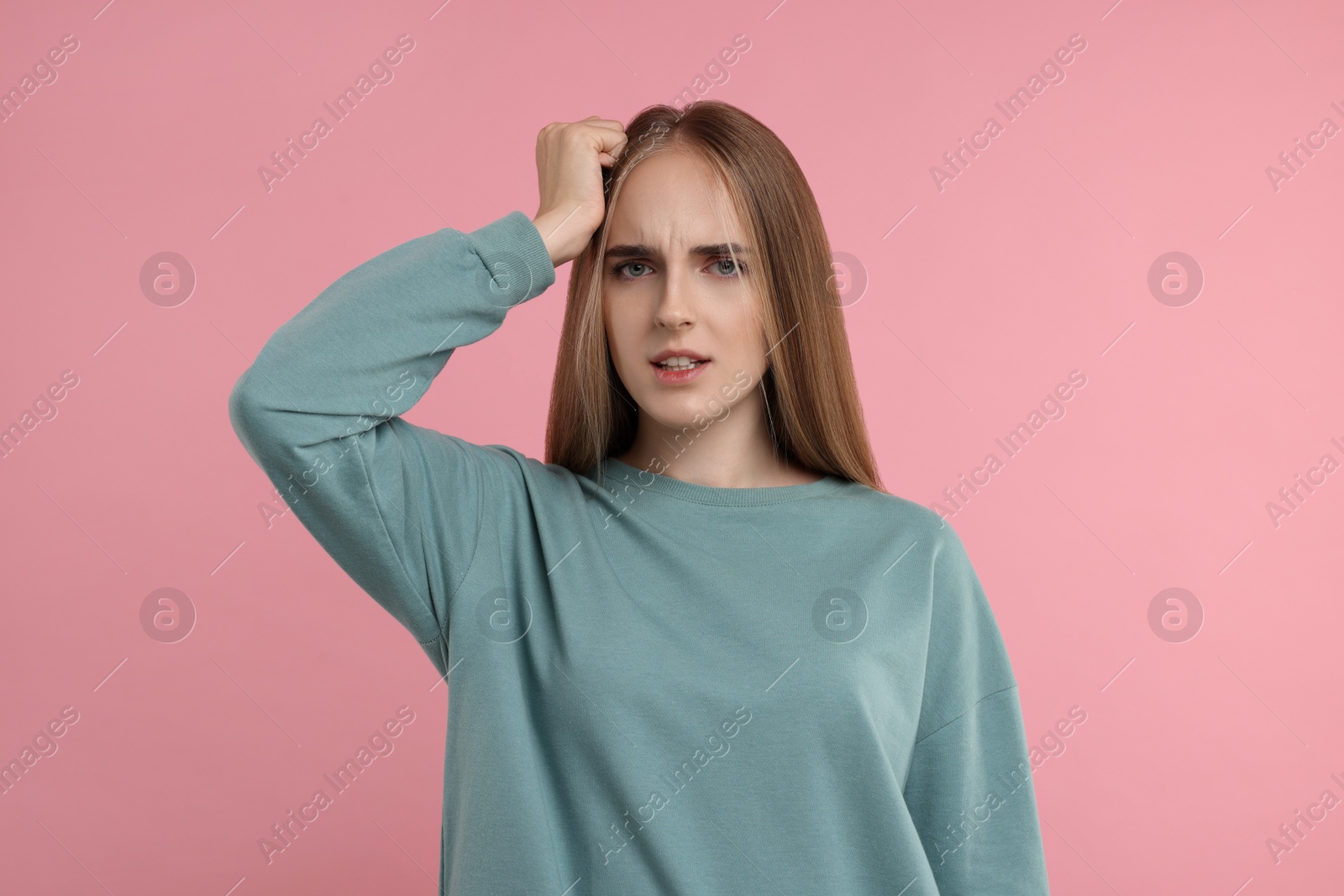 Photo of Portrait of embarrassed young woman on pink background