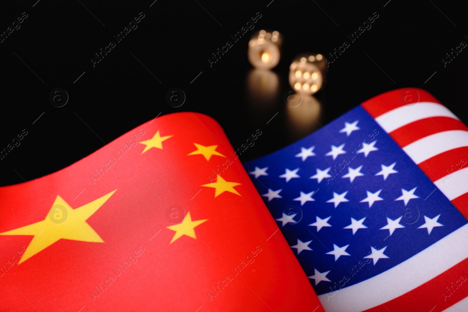 Photo of USA and China flags with dices on black table. International relations