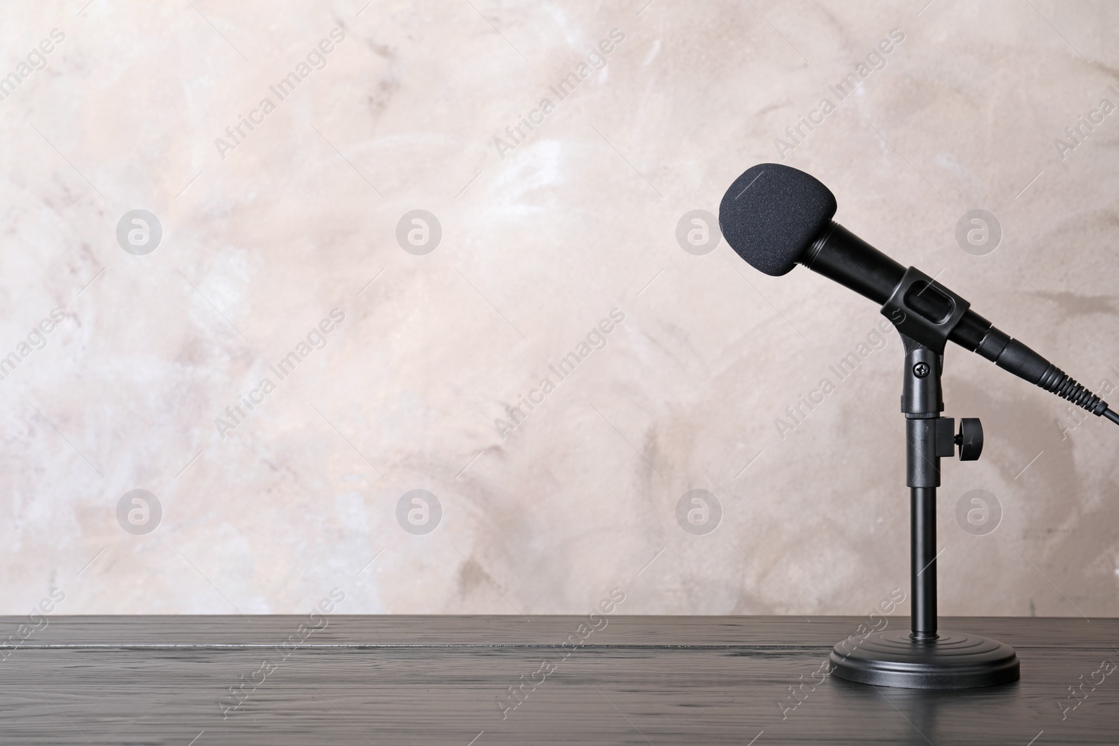 Photo of Microphone on table against color background. Space for text