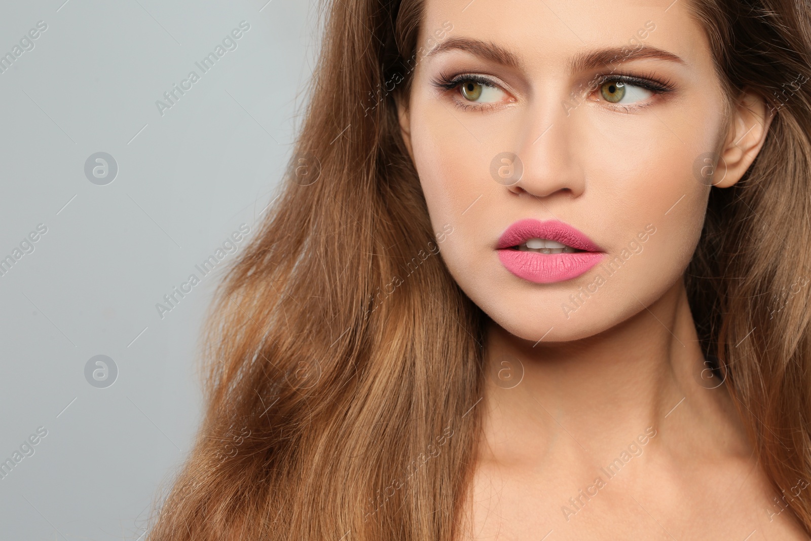 Photo of Young woman wearing beautiful lipstick on gray background