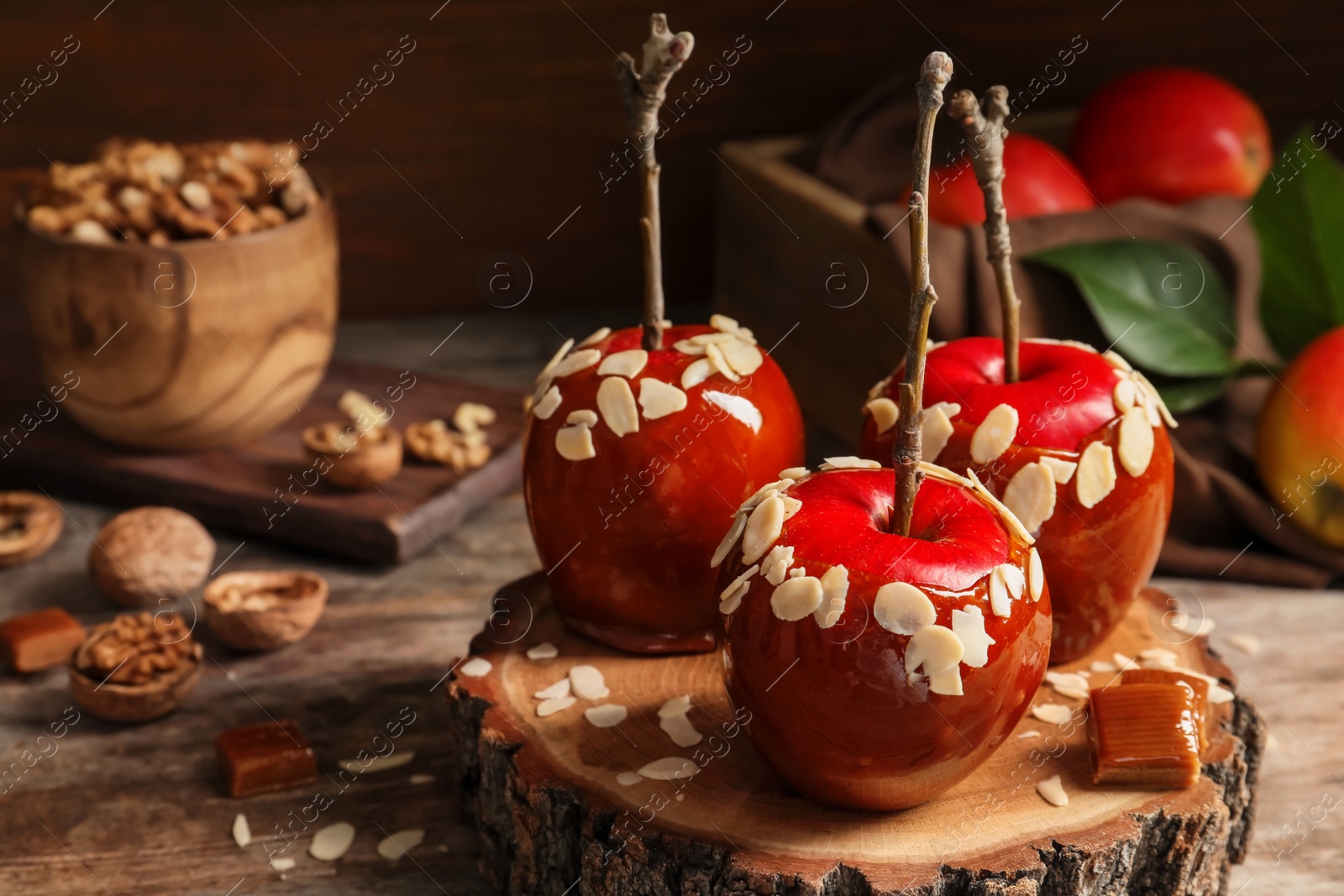 Photo of Delicious caramel apples on wooden serving board