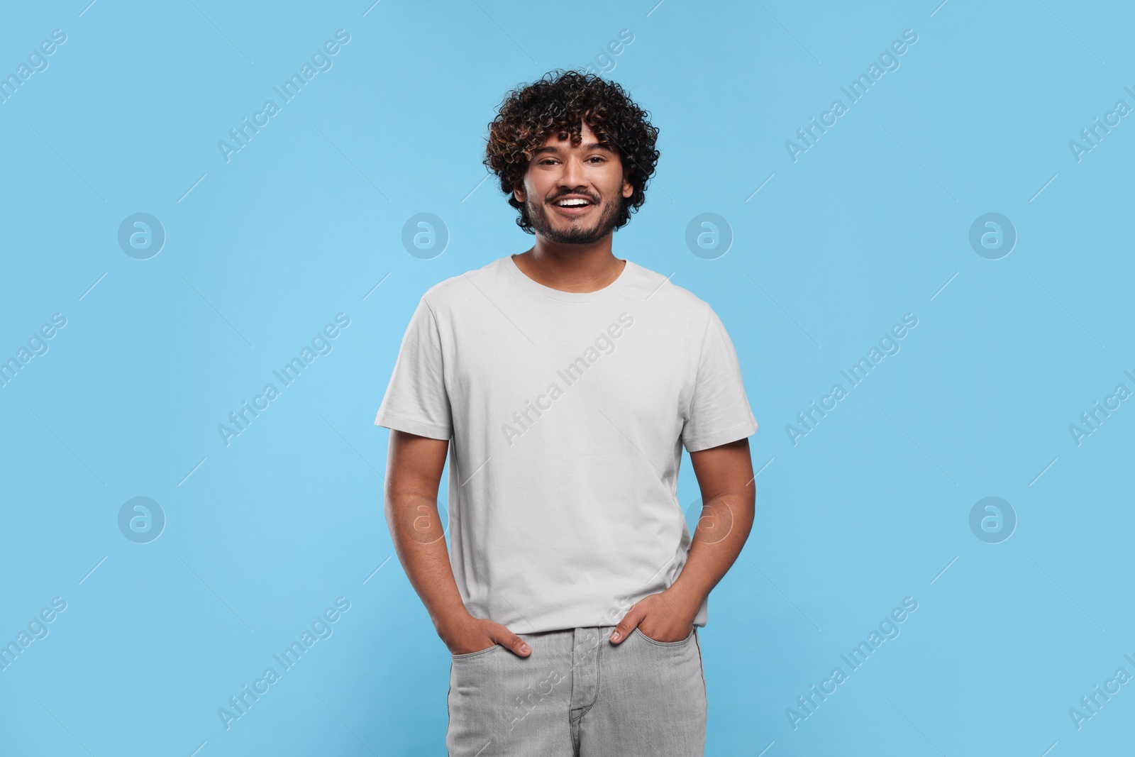 Photo of Handsome smiling man on light blue background