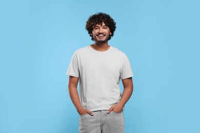 Photo of Handsome smiling man on light blue background