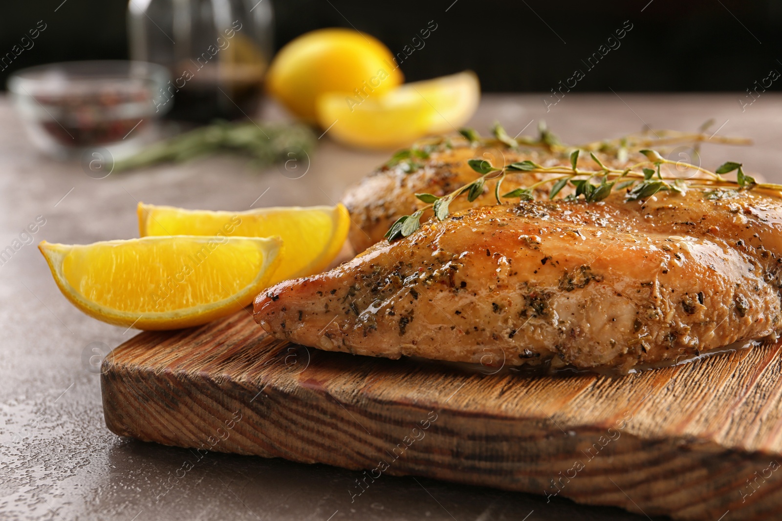 Photo of Baked lemon chicken with thyme served on grey marble table