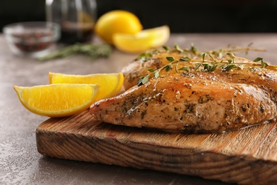 Baked lemon chicken with thyme served on grey marble table