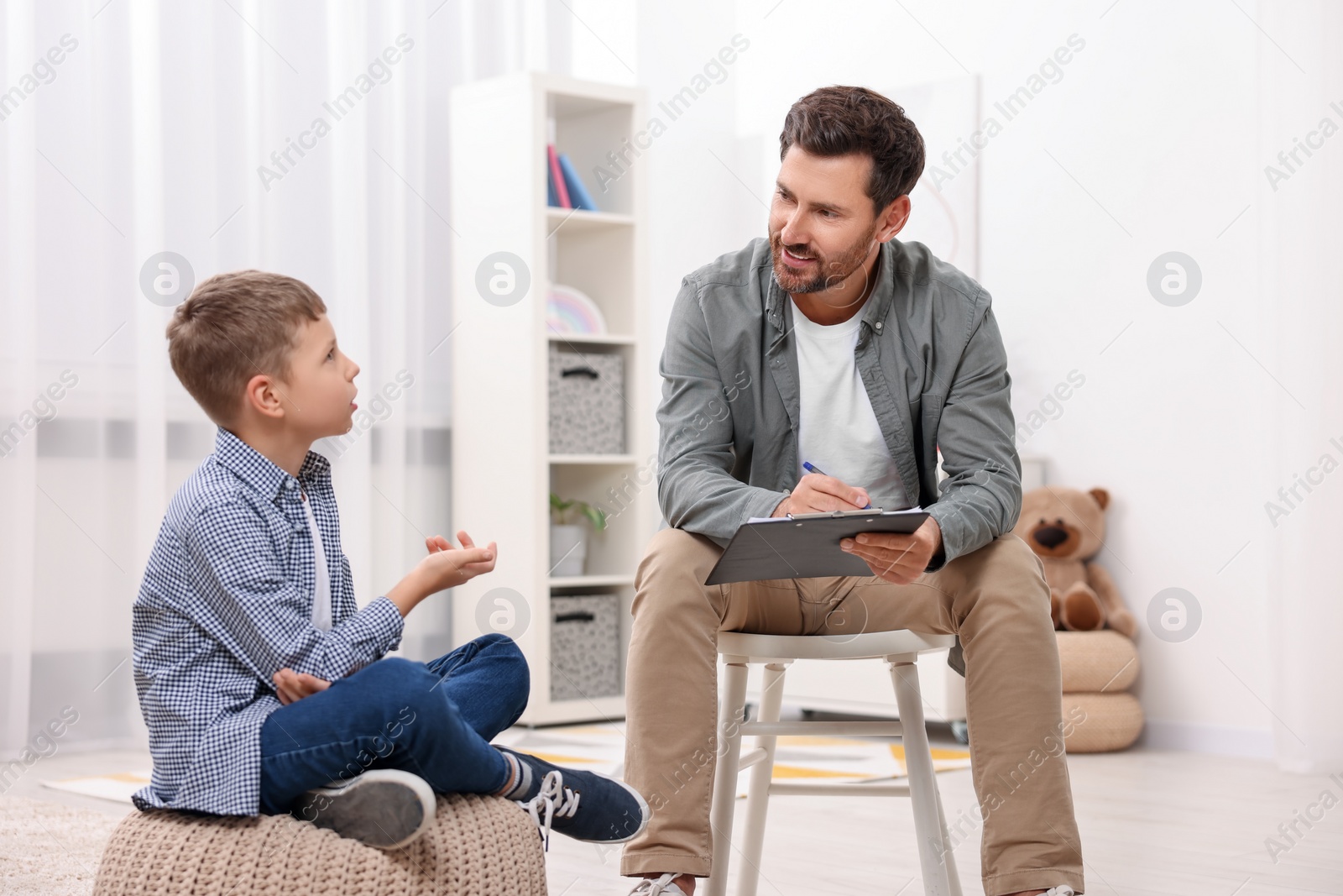 Photo of Dyslexia treatment. Therapist working with boy in room