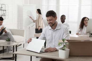 New coworker with laptop at workplace in office