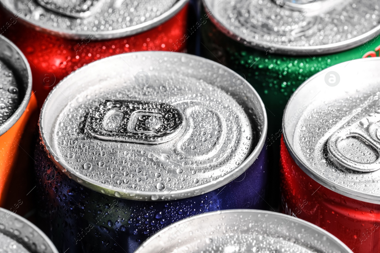 Photo of Aluminum cans of beverage covered with water drops as background, closeup