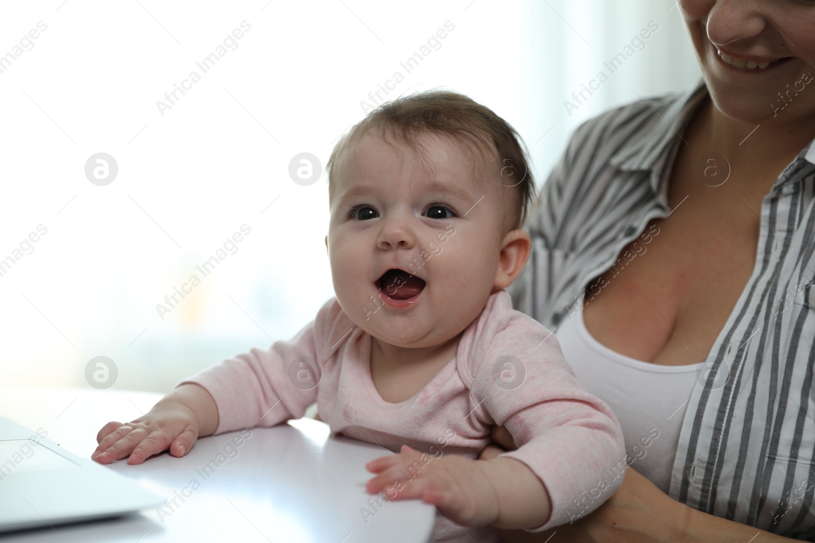 Photo of Young woman with her cute baby at home