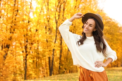 Beautiful happy woman wearing hat in park. Autumn walk