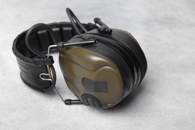 Tactical headphones on light gray background, closeup. Military training equipment