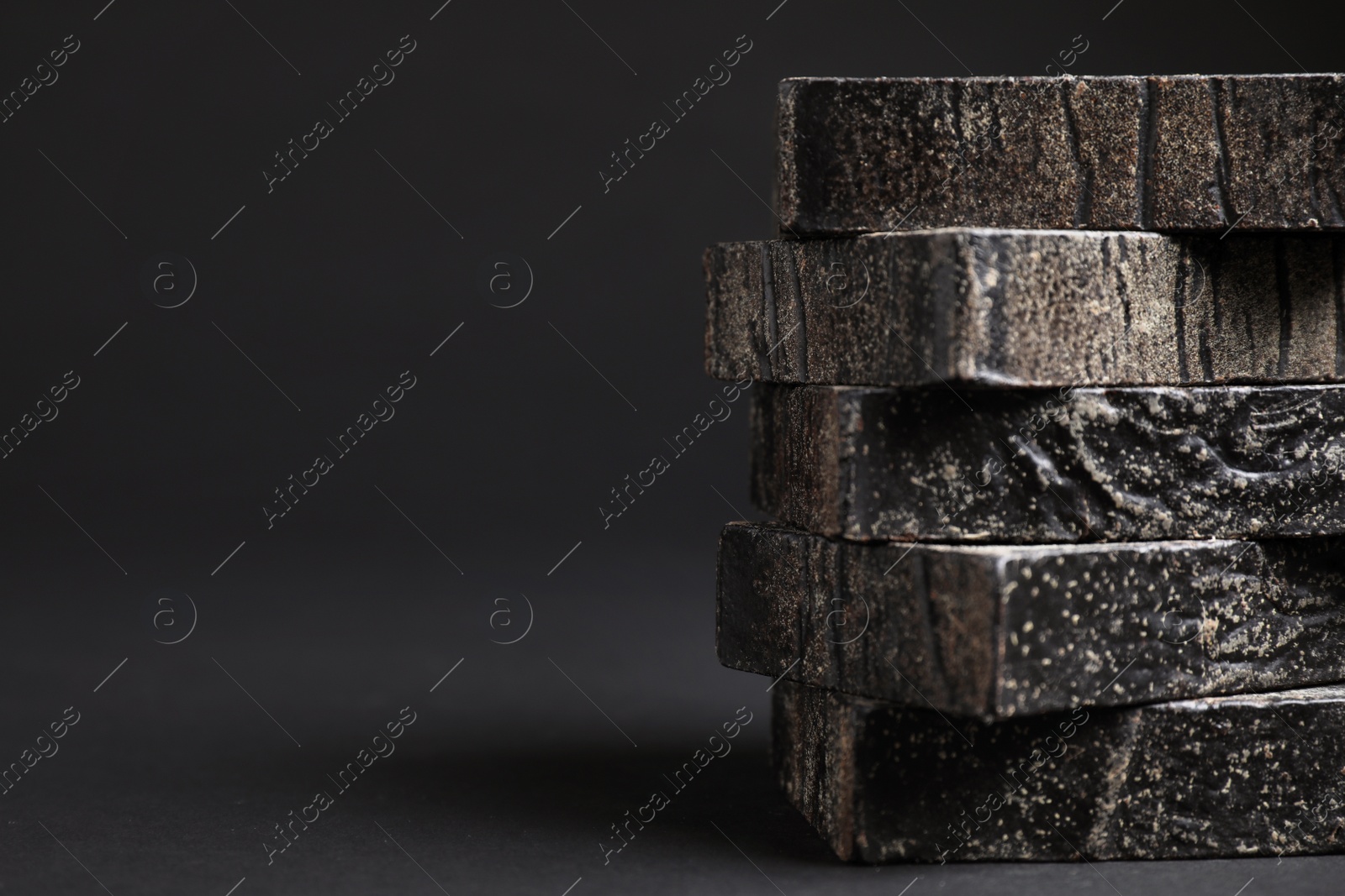 Photo of Natural tar soap on black table, closeup. Space for text