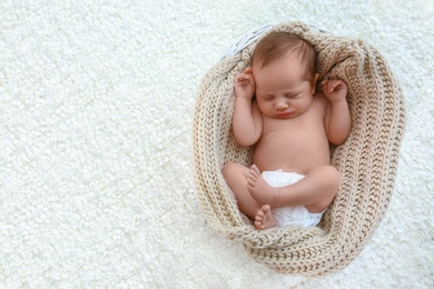 Photo of Cute little baby sleeping in cradle on light background, top view. Space for text