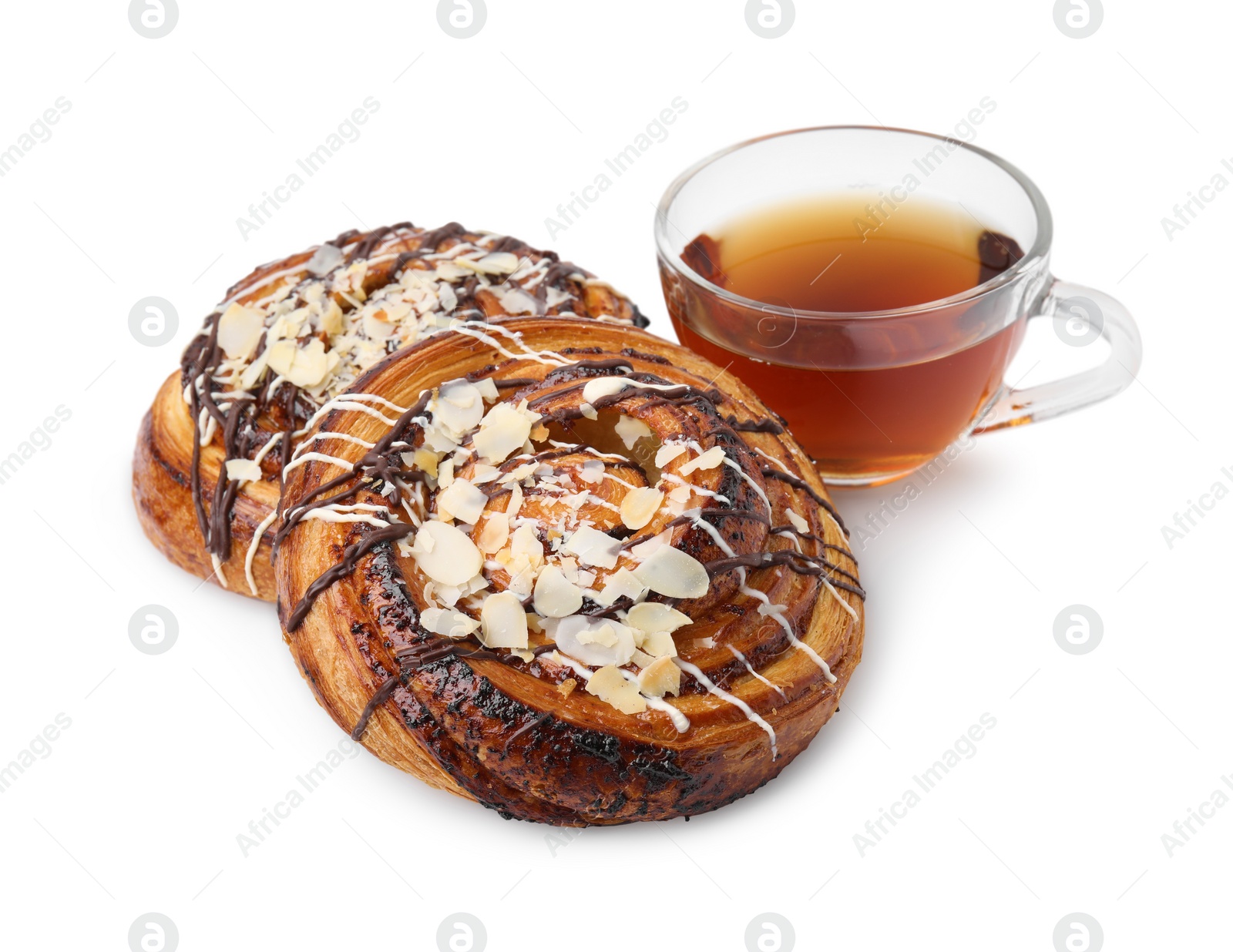 Photo of Delicious rolls with toppings, almond and cup of tea isolated on white. Sweet buns