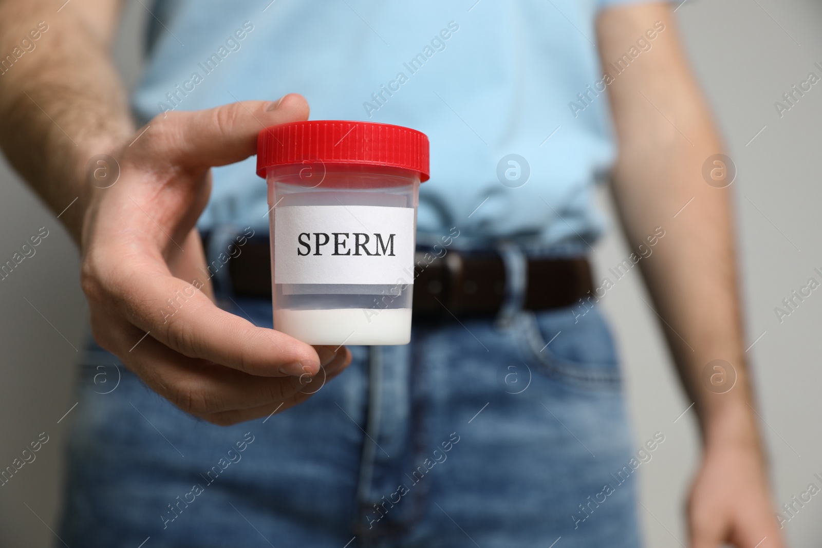 Photo of Donor holding container with sperm, closeup view