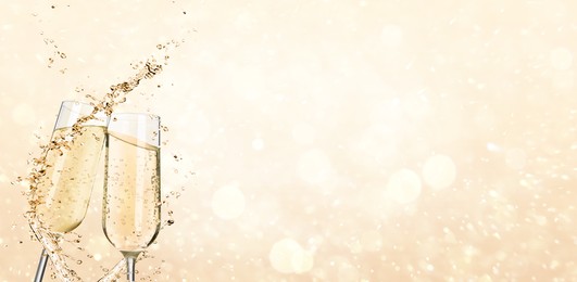 Image of Glasses with sparkling wine and splashes on light background, space for text. Banner design