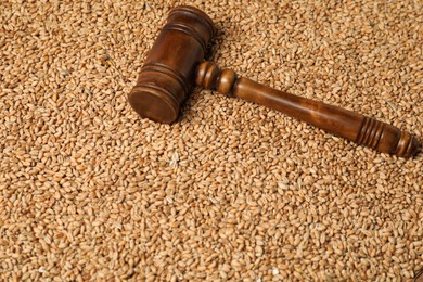 Photo of Wooden gavel on wheat grains. Agricultural deal