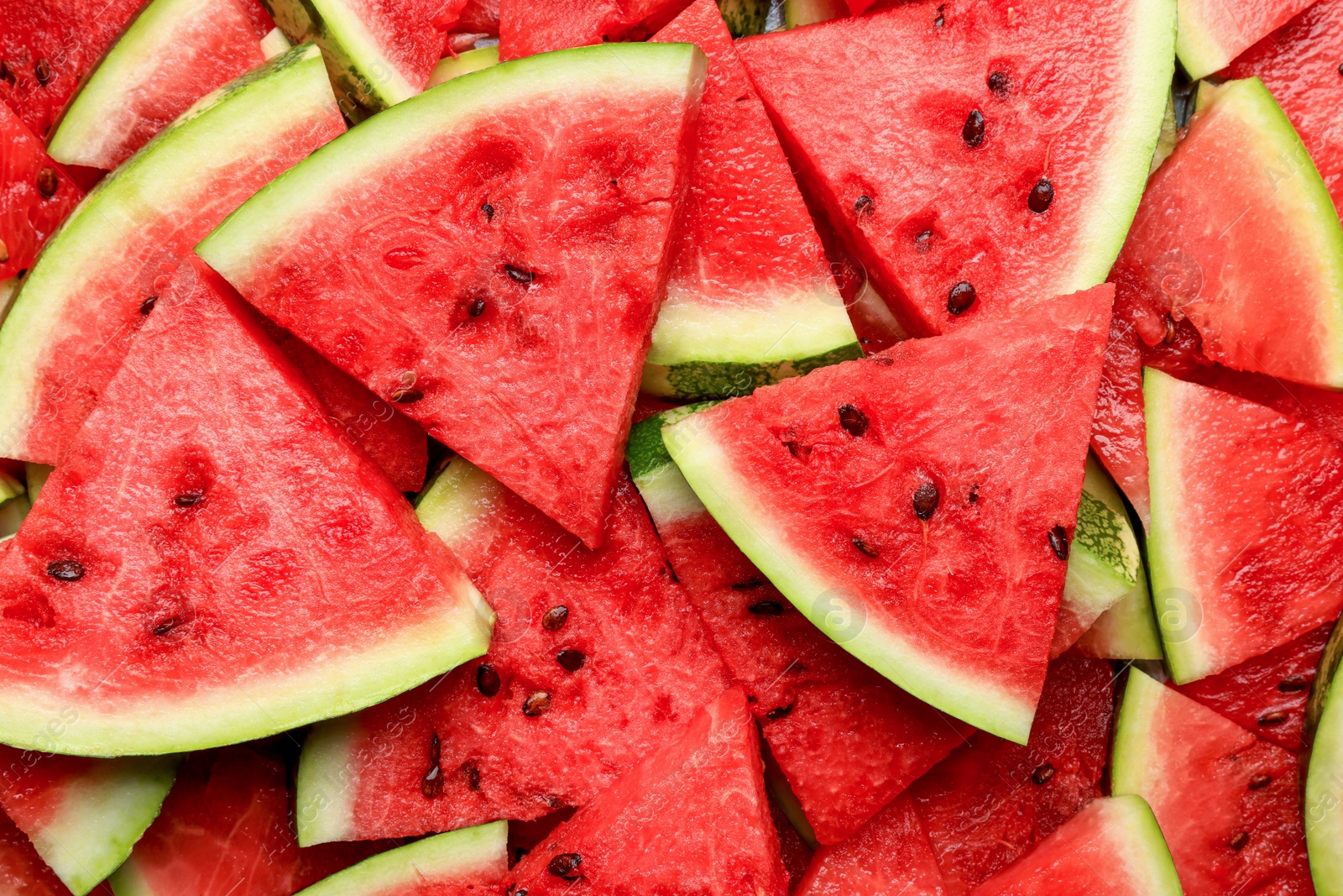 Photo of Slices of juicy ripe watermelon as background, top view