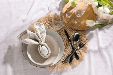 Easter table setting with bunny ears made of egg and napkin, flat lay