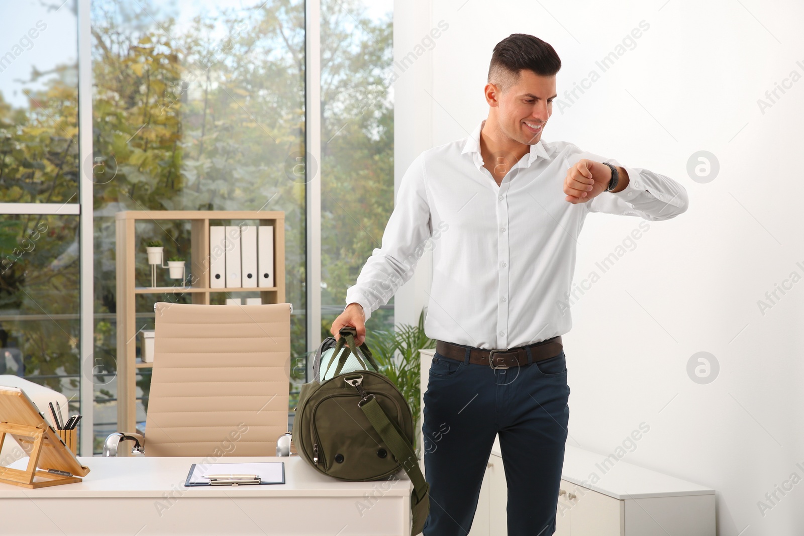 Photo of Handsome businessman with sports bag in office