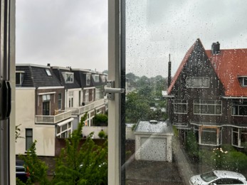 Photo of Beautiful cityscape with buildings on rainy day, view through open window