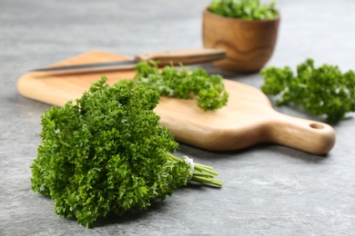 Photo of Bunch of fresh curly parsley on grey table