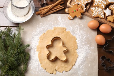 Photo of Making Christmas cookies. Flat lay composition with ingredients and raw dough on wooden table