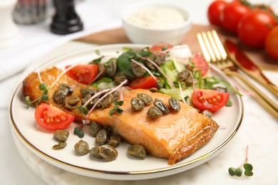 Delicious salmon with salad and capers on white table, closeup