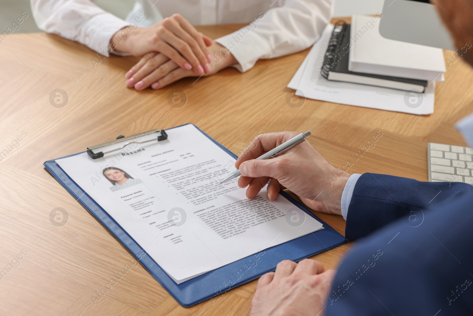 Photo of Human resources manager reading applicant's resume in office, closeup