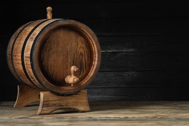 Wooden barrel with tap on table, space for text