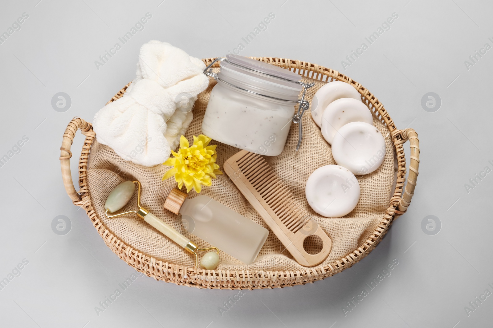 Photo of Spa gift set with different products in wicker basket on light grey background, top view