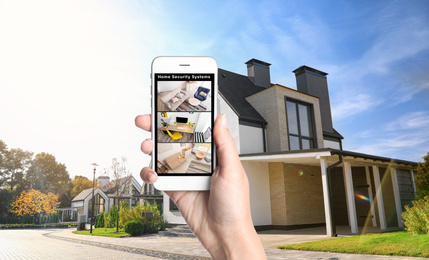 Image of Alarm system. Woman monitoring modern CCTV cameras on smartphone near her house, closeup