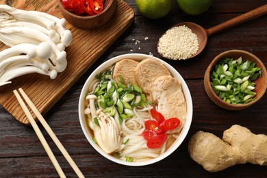 Photo of Delicious ramen with meat and ingredients on wooden table, flat lay. Noodle soup