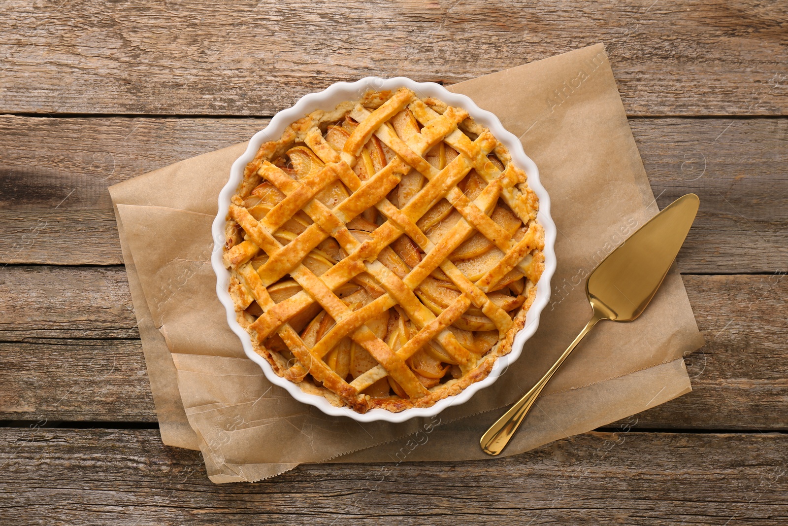 Photo of Tasty homemade quince pie and cake server on wooden table, flat lay