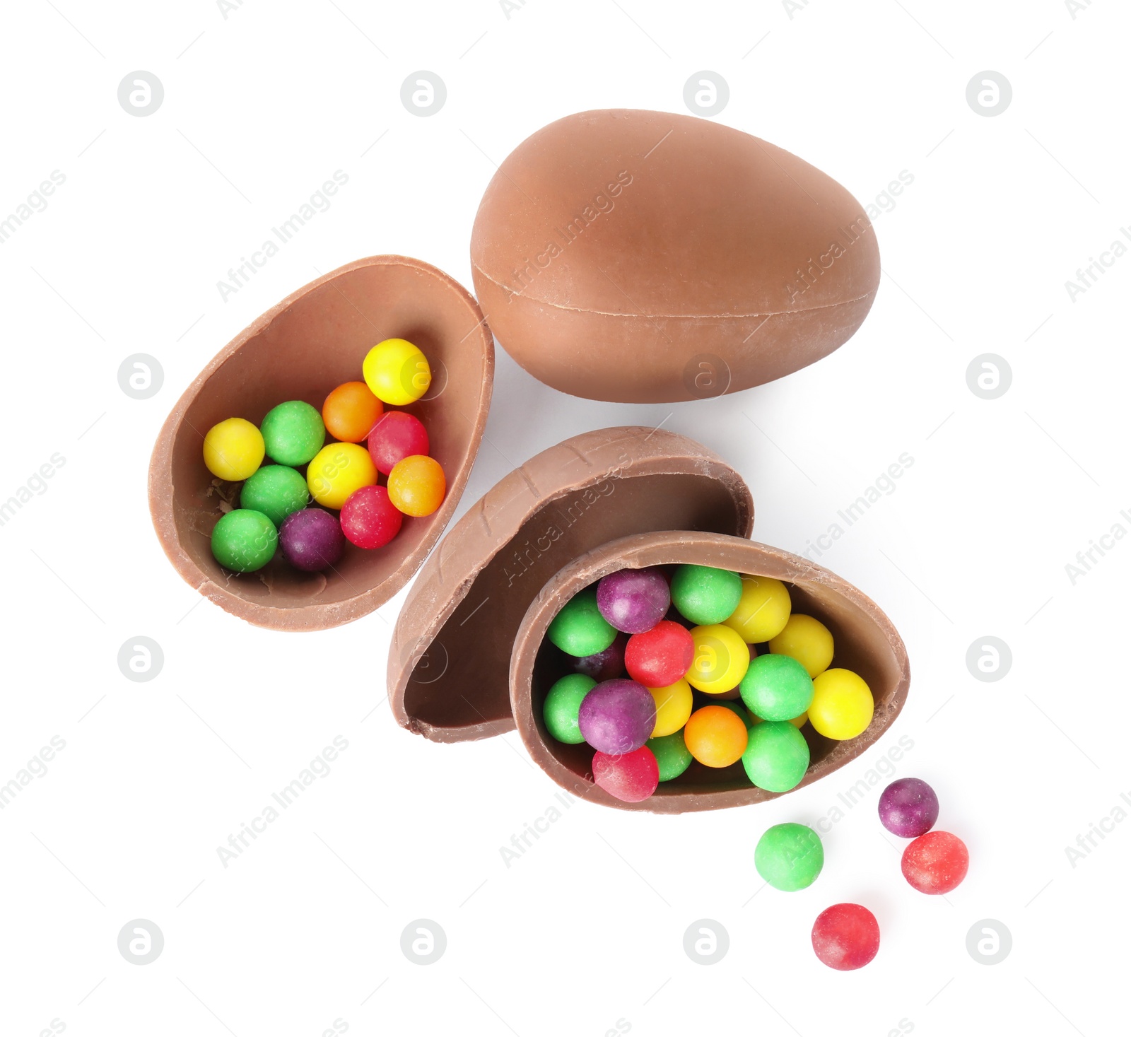 Photo of Tasty chocolate eggs with colorful candies on white background, top view