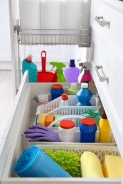 Photo of Different cleaning supplies in open drawers indoors