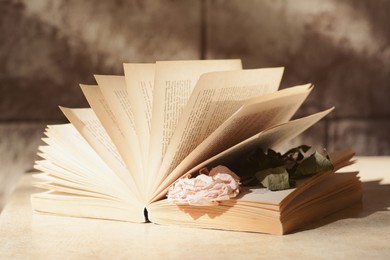 Book with beautiful dried flower on light table