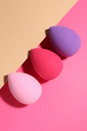 Photo of Many different makeup sponges on color background, flat lay