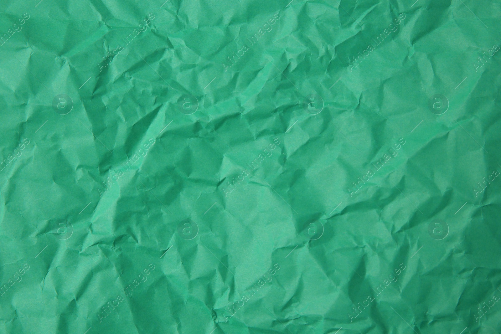 Photo of Sheet of crumpled green paper as background, top view