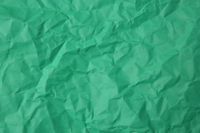 Sheet of crumpled green paper as background, top view