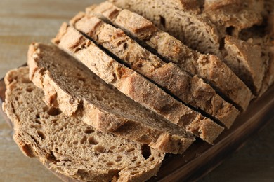 Photo of Freshly baked cut sourdough bread on wooden table, closeup