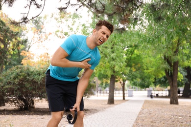 Young man having heart attack while running in park