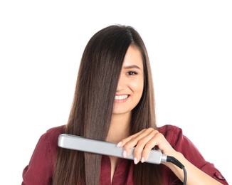 Photo of Young woman using hair iron on white background