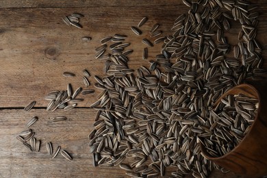 Photo of Organic sunflower seeds on wooden table, flat lay