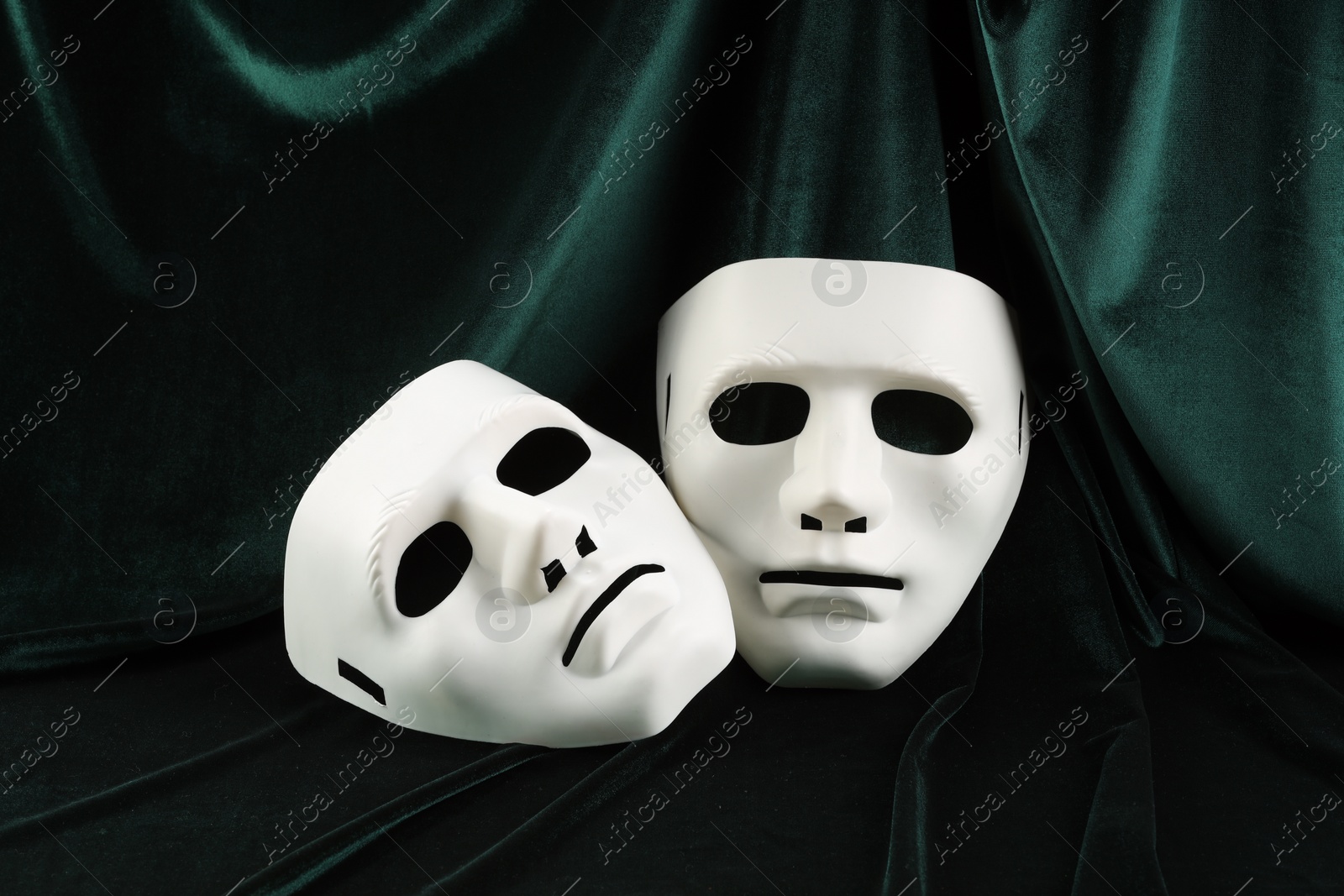 Photo of Theater arts. Two white masks on green fabric