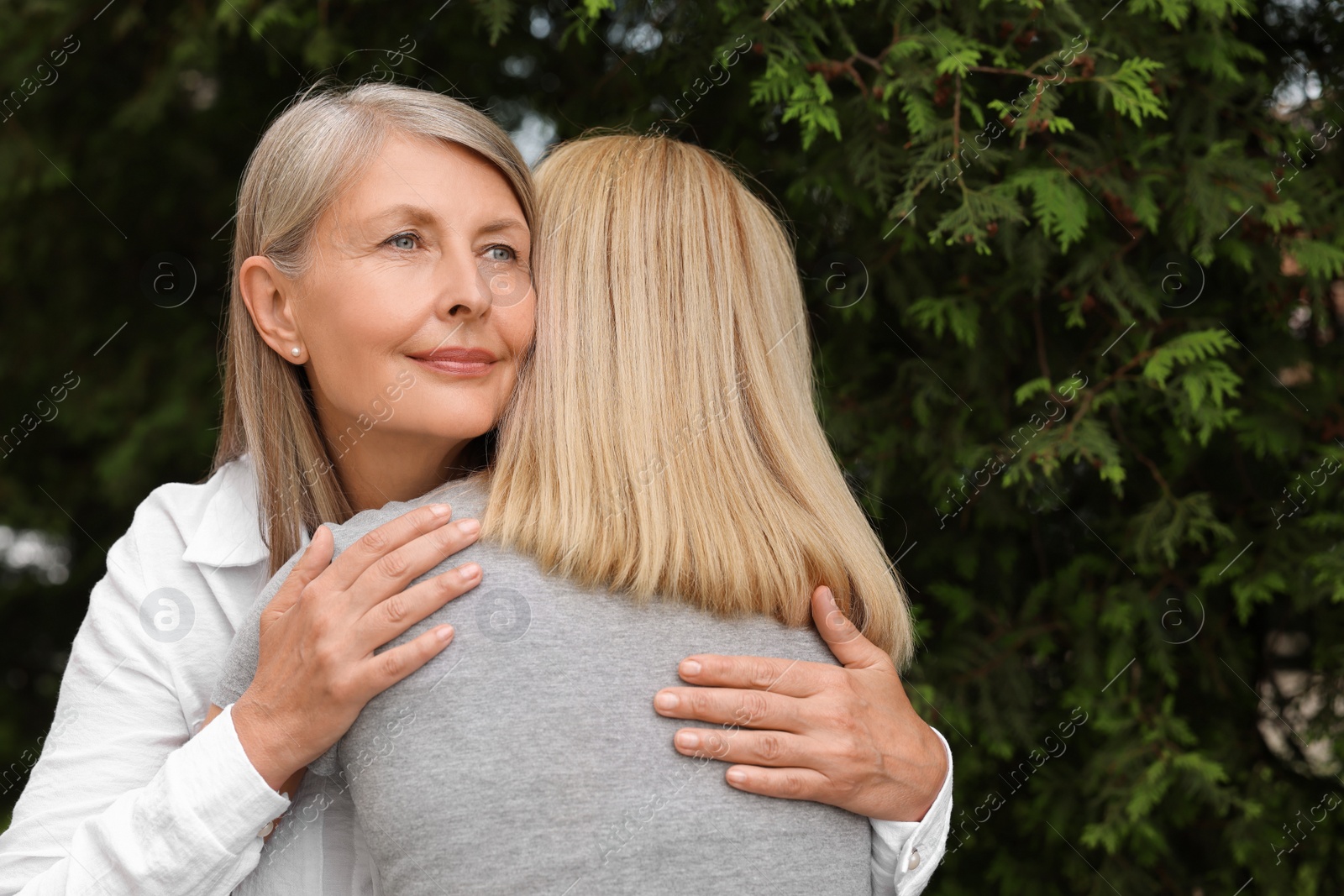 Photo of Happy mature mother hugging her daughter outdoors