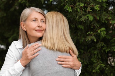 Photo of Happy mature mother hugging her daughter outdoors