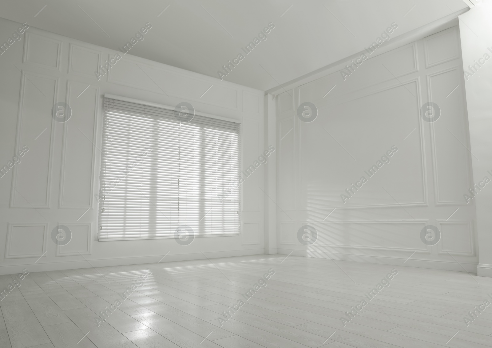 Photo of Empty room with white walls, large window and wooden floor