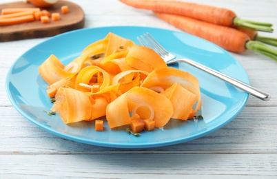 Plate with tasty carrot salad on table