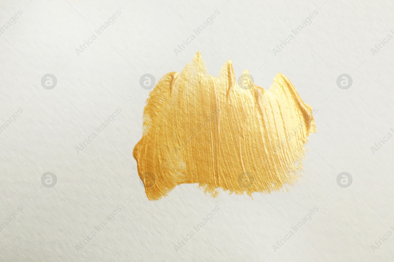 Photo of Golden paint brush strokes on white background